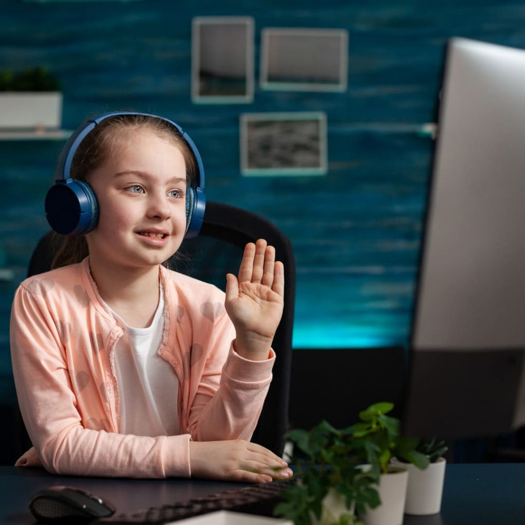 little schoolchild wearing headset greeting remote 2022 01 19 00 06 18 utc